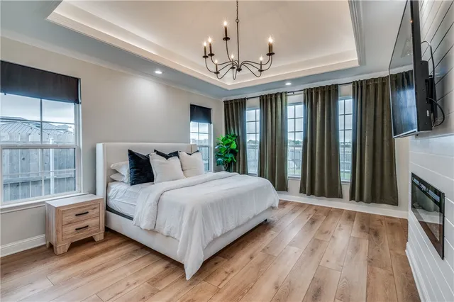 a spacious bedroom with a large bed and a chandelier