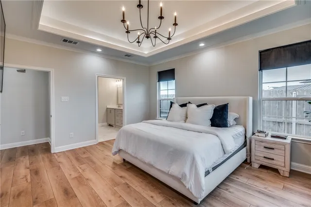 a bedroom with bed and a chandelier
