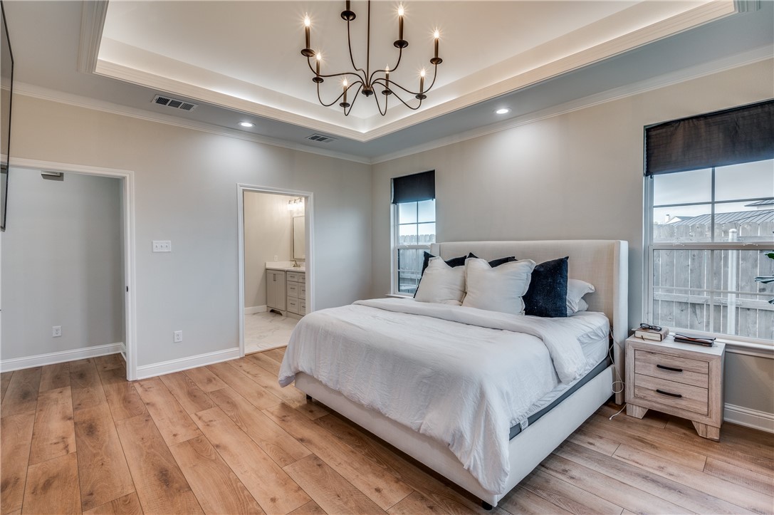 164 Water View Lane Robinson, TX 76706 - Photo 16 of 26 a bedroom with bed and a chandelier