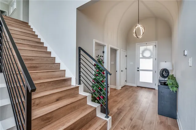 a view of a hallway with wooden floor and stairs