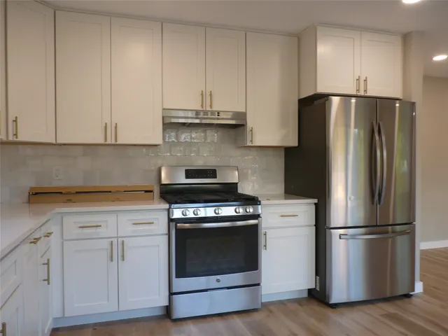 a kitchen with cabinets and stainless steel appliances