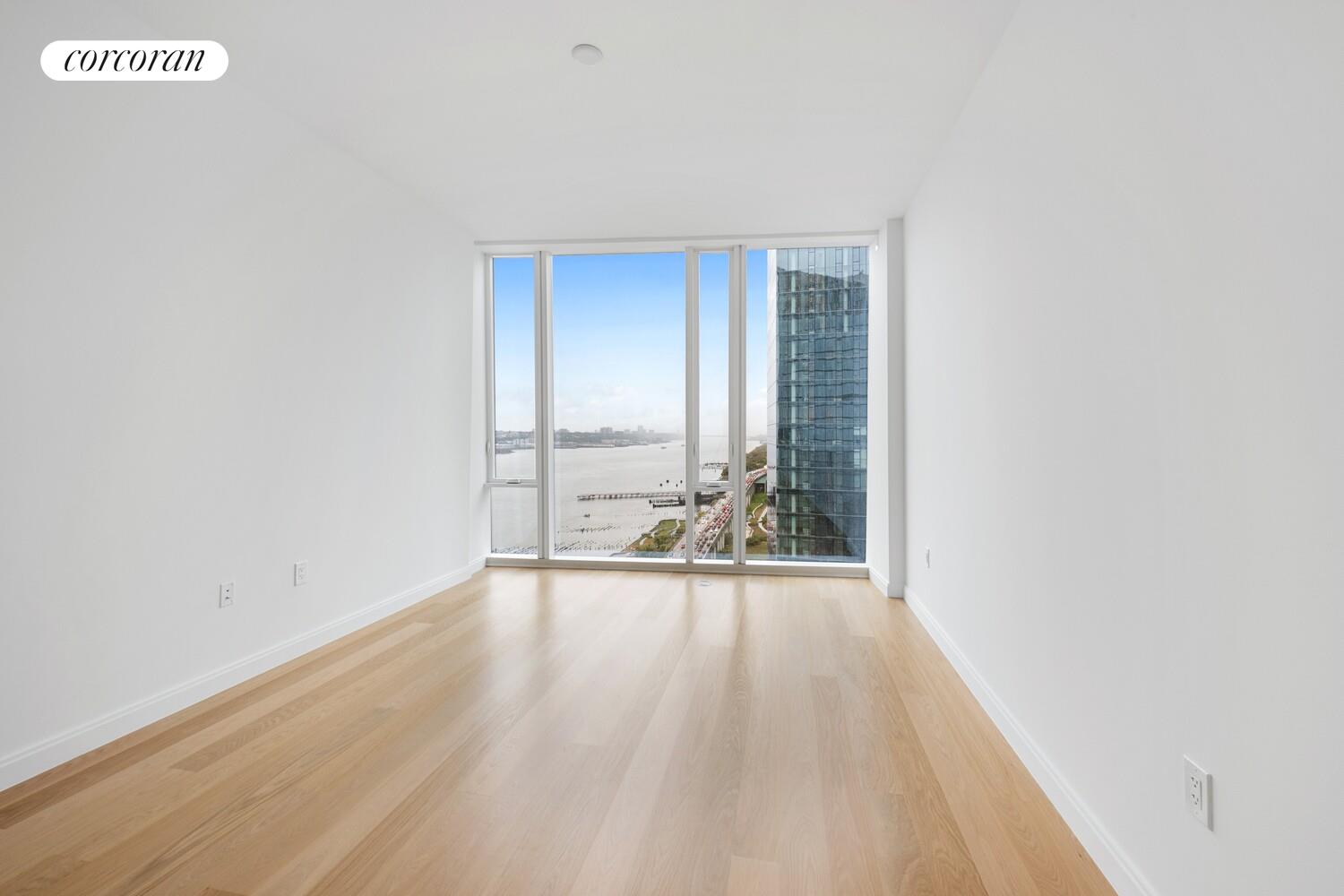 10 Riverside Boulevard, Unit 27C Manhattan, NY 10069 - Photo 5 of 14 a view of an empty room with wooden floor and a window