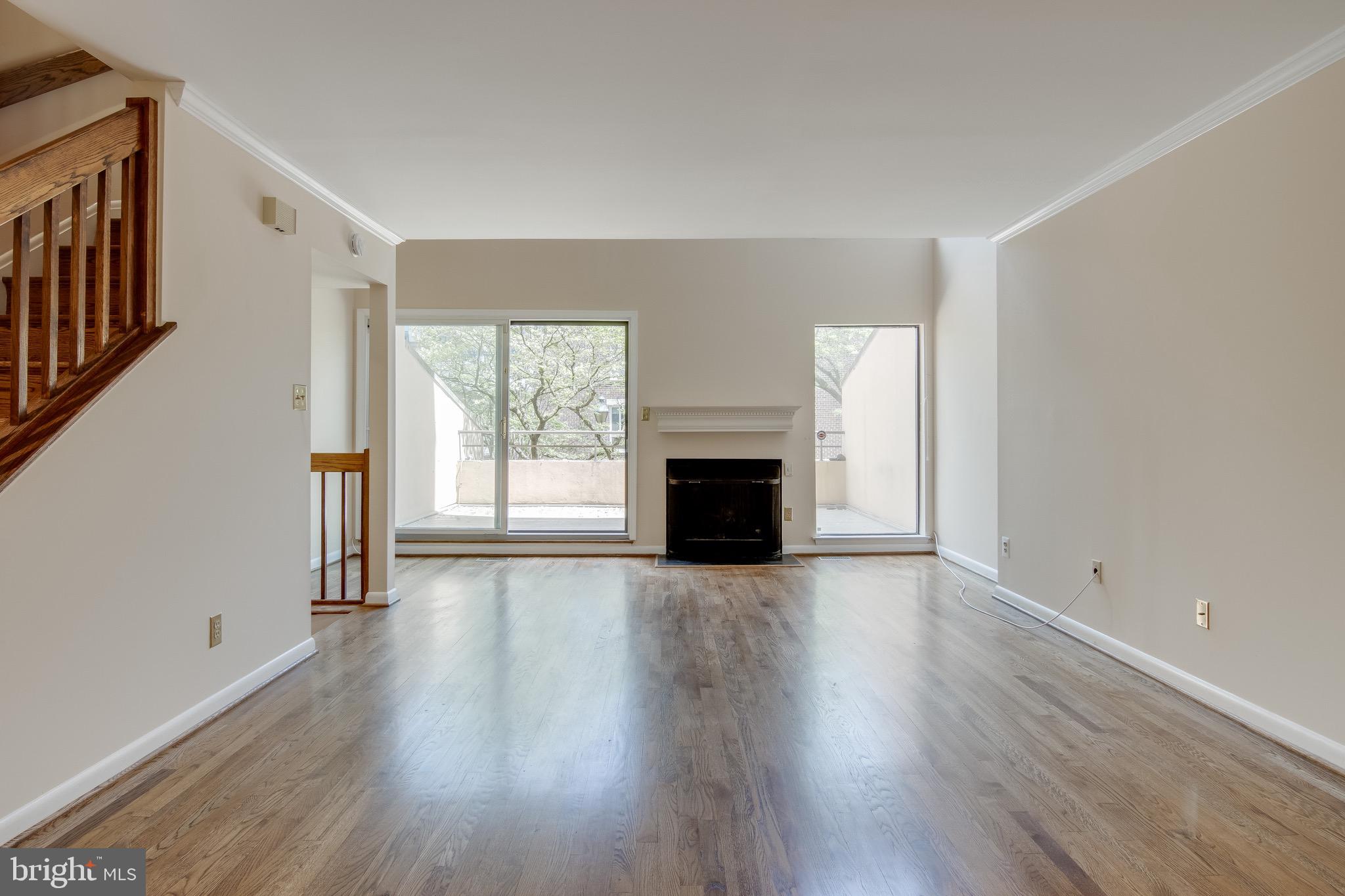 627 South Hanover Street Baltimore, MD 21230 - Photo 9 of 41 an empty room with wooden floor fireplace and windows