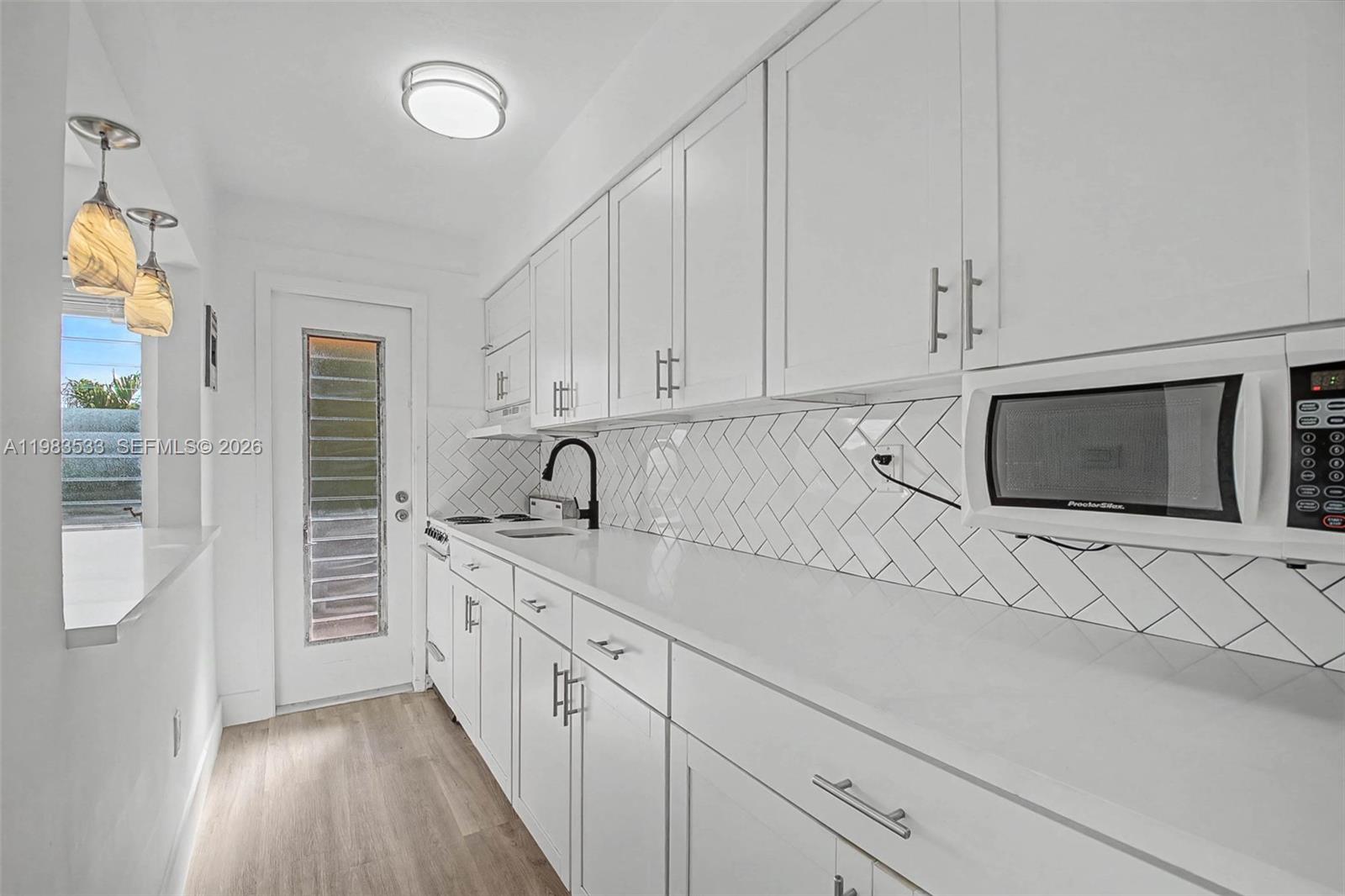 a kitchen with stainless steel appliances white cabinets and a sink