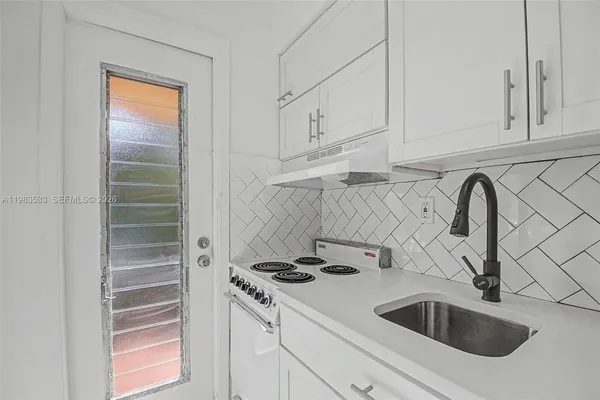 a kitchen with white cabinets and a sink