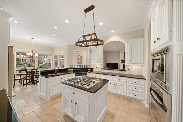 a kitchen with stainless steel appliances granite countertop a sink a stove a refrigerator and island