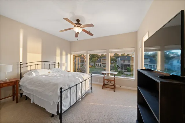 a bedroom with a bed and a large window with outer view