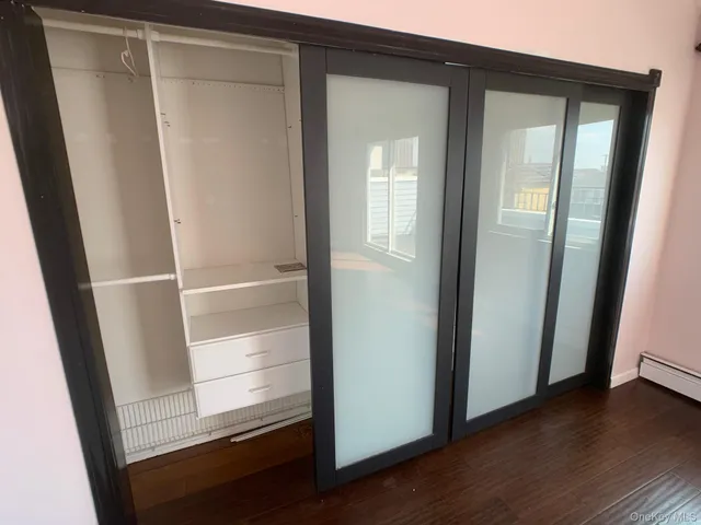 a view of walk in closet with wooden floor