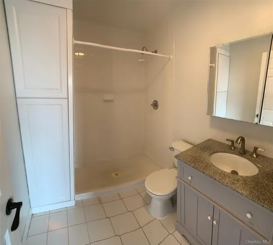 a bathroom with a granite countertop sink a toilet and a mirror