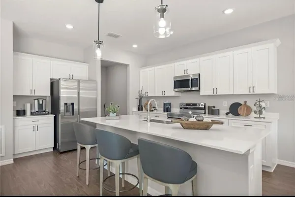 a kitchen with a sink stainless steel appliances and white cabinets