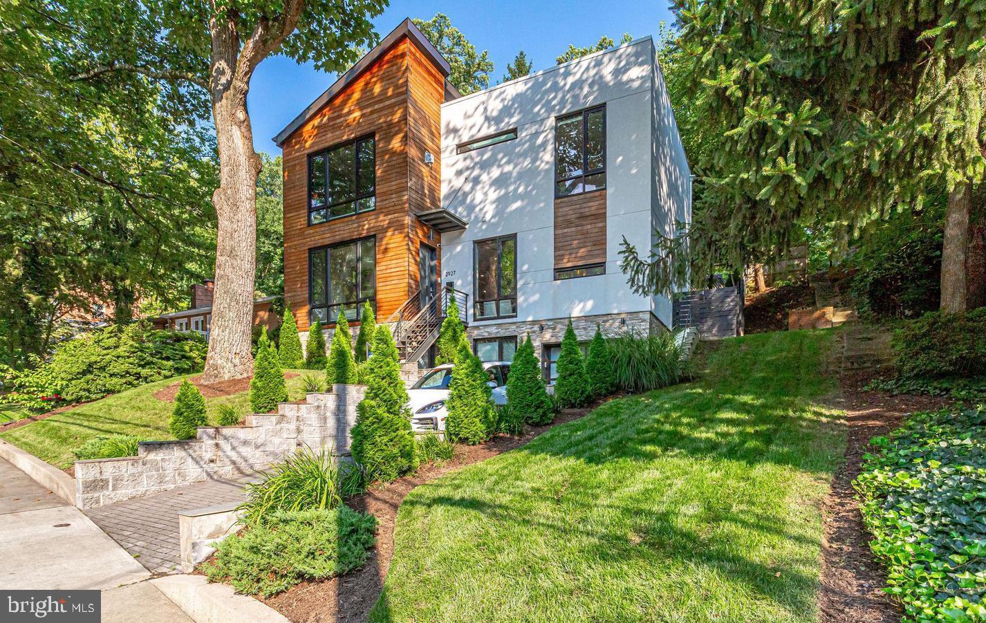 2927 Arizona Avenue Northwest Washington, DC 20016 - Photo 1 of 18 a view of a brick house with a big yard plants and large trees