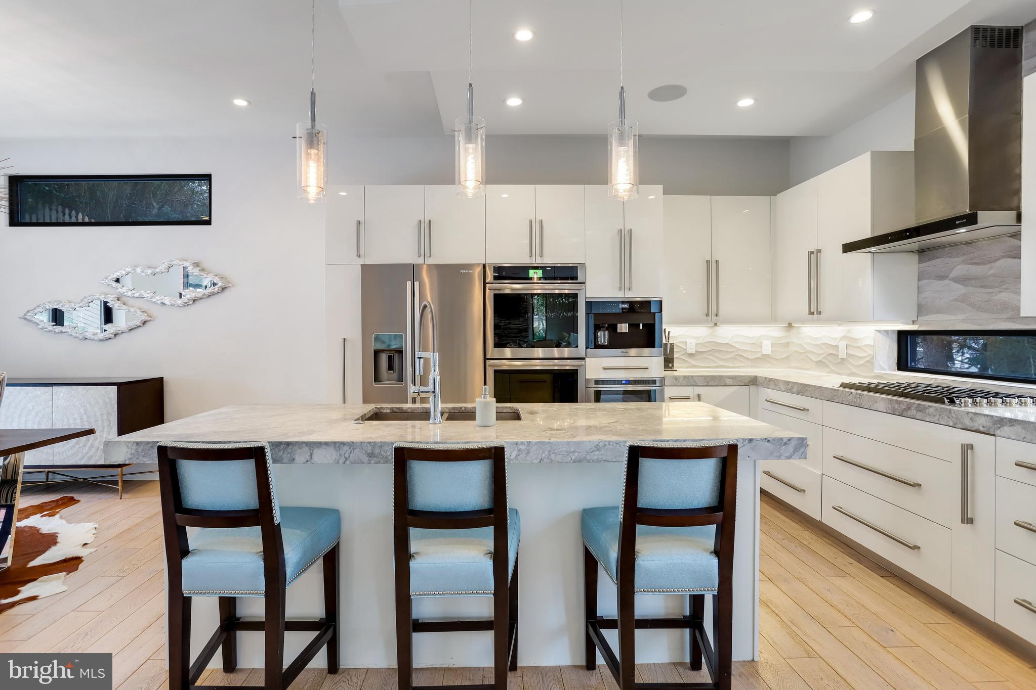 2927 Arizona Avenue Northwest Washington, DC 20016 - Photo 6 of 18 a kitchen with stainless steel appliances kitchen island granite countertop a table chairs microwave and sink