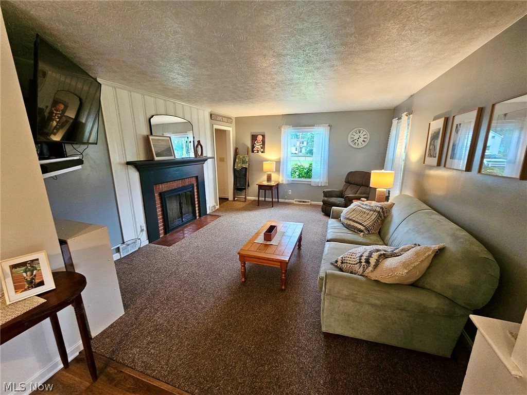 6620 West Lake Road Vermilion, OH 44089 - Photo 16 of 34 Living area with fireplace featuring a black mantel, brick surround, and hearth