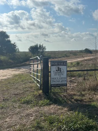 a view of a dry yard with mountains in the background