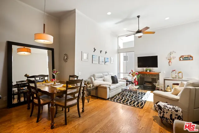 a living room with furniture kitchen view and a flat screen tv