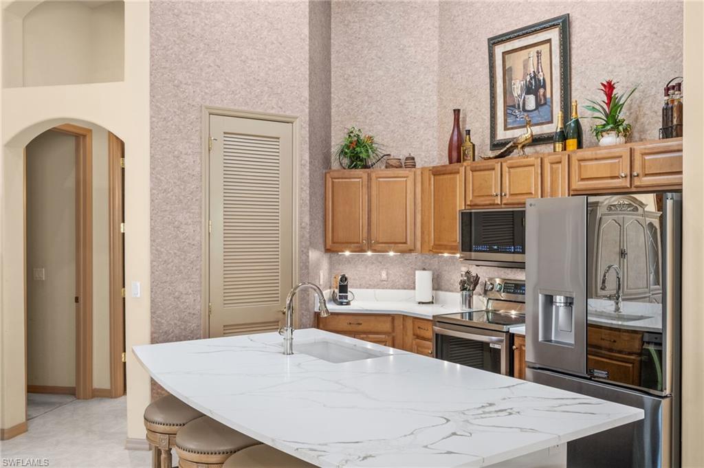 15214 Cape Sable Lane Fort Myers, FL 33908 - Photo 13 of 50 a kitchen with stainless steel appliances granite countertop a refrigerator a stove and a sink with wooden floor