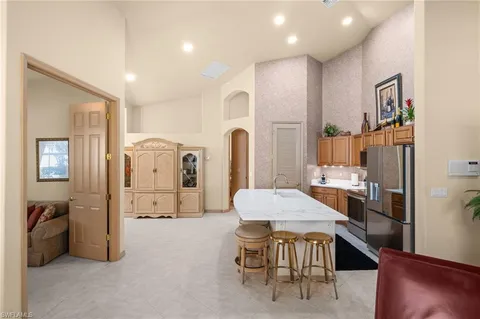 a kitchen with stainless steel appliances granite countertop a refrigerator a stove and a sink with wooden floor