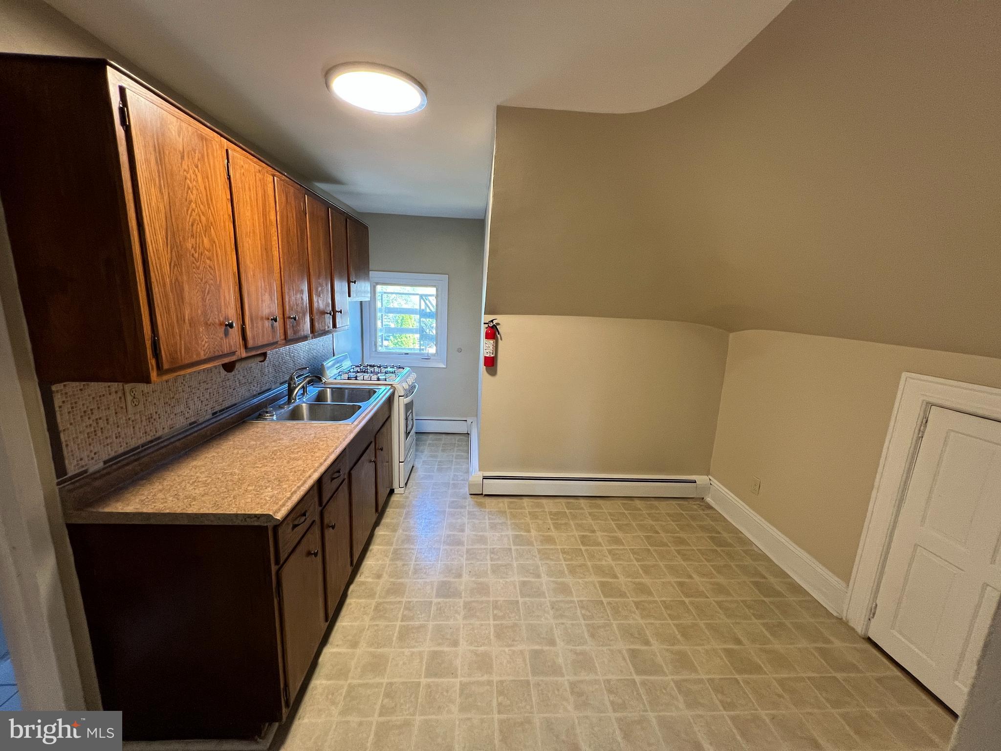 1050 Stuyvesant Avenue Trenton, NJ 08618 - Photo 10 of 11 a kitchen with a sink a counter top space and cabinets