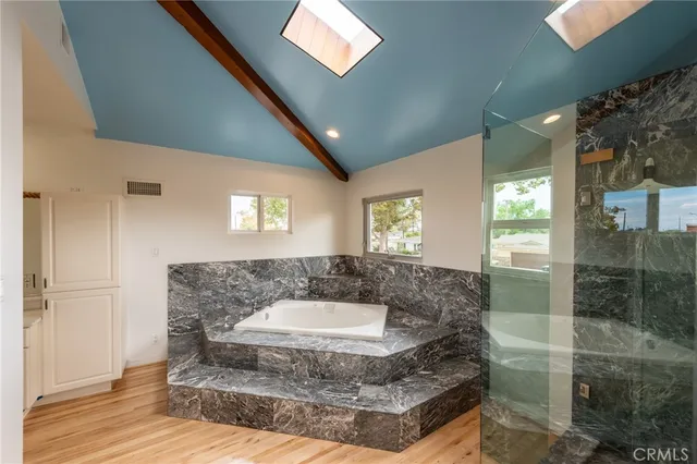 a spacious bathroom with a granite countertop sink a mirror and shower