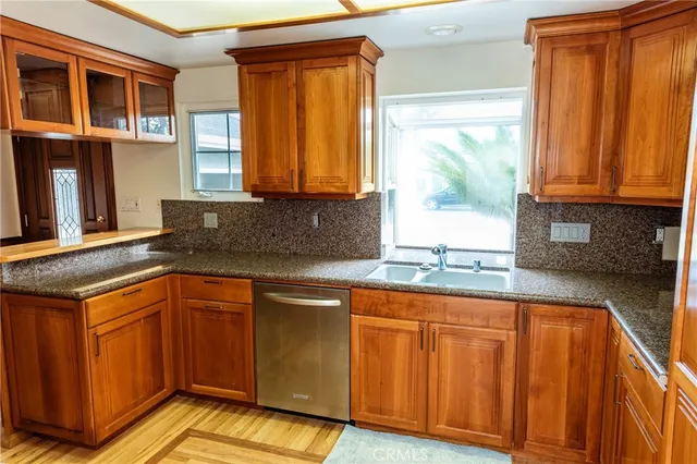 a kitchen with granite countertop wooden cabinets a sink and a window