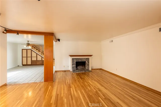 a view of a livingroom with wooden floor and a fireplace