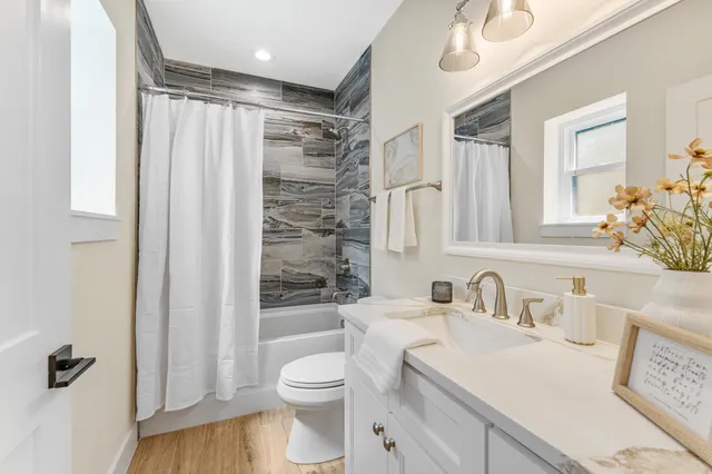 a bathroom with a sink a toilet and shower