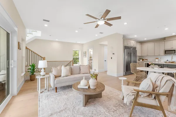 a living room with furniture kitchen view and a potted plant