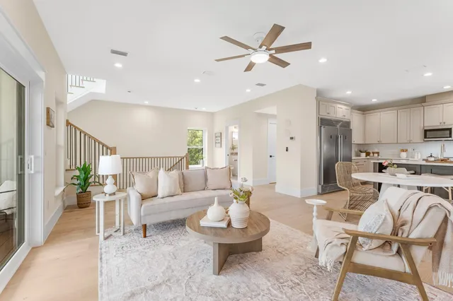 a living room with furniture kitchen view and a potted plant