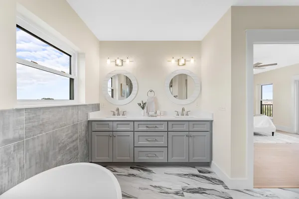 a spacious bedroom with a large bed and a chandelier