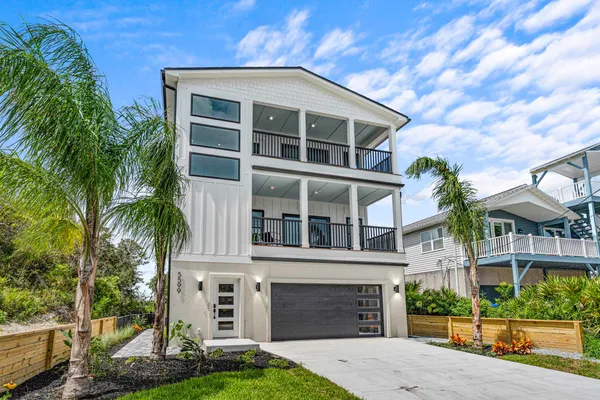 a front view of a house with a yard and potted plants
