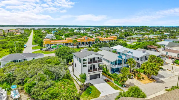 an aerial view of a house with a garden and lake view