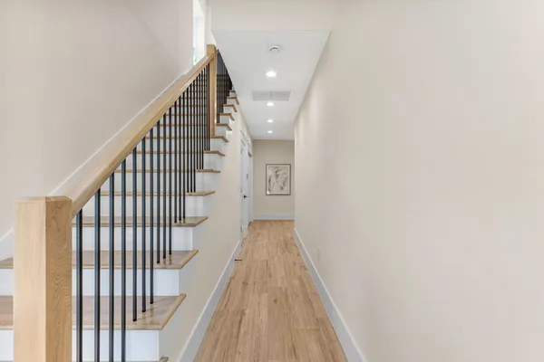 a view of a hallway with wooden floor and entryway