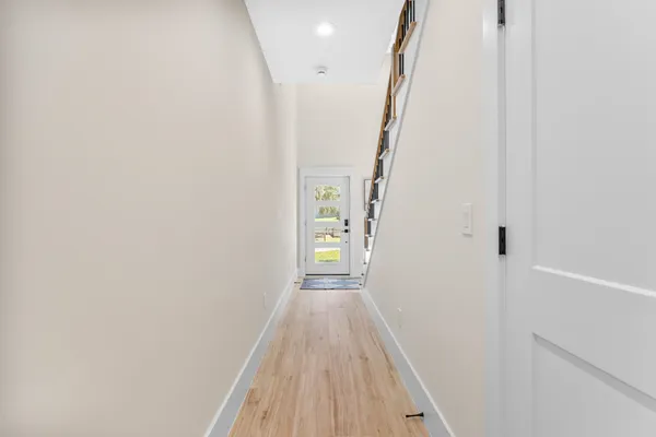 a view of a hallway with wooden floor and staircase