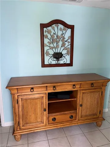 a bedroom with a bed and a lamp on dresser