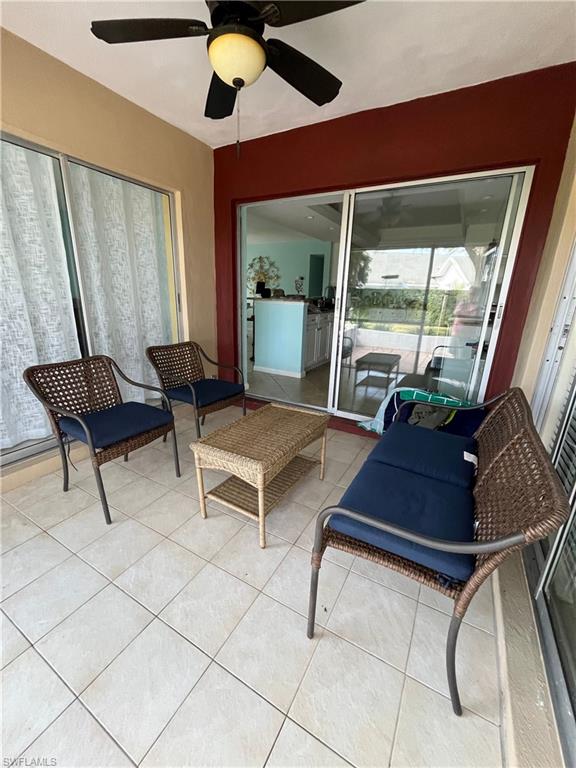 240 Palm River Boulevard, Unit C102 Naples, FL 34110 - Photo 5 of 17 a living room with furniture and a floor to ceiling window