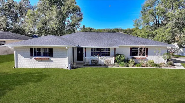 a front view of a house with a yard and tree