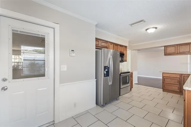a kitchen with stainless steel appliances a refrigerator and a stove top oven