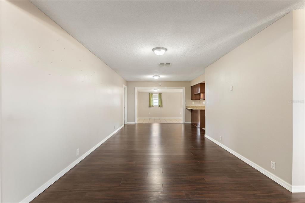 130 Audubon Road Winter Haven, FL 33884 - Photo 16 of 46 a view of empty room with wooden floor and kitchen