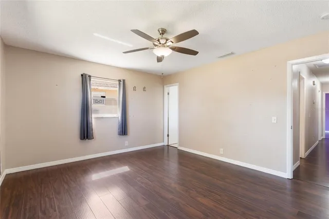a view of wooden floor and a chandelier fan in a room