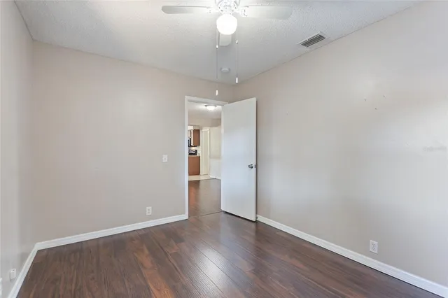 a view of a room with wooden floor and a ceiling fan