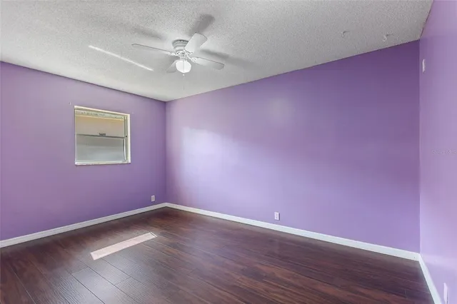 a view of a big room with wooden floor and a ceiling fan