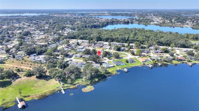 an aerial view of ocean and residential houses with outdoor space