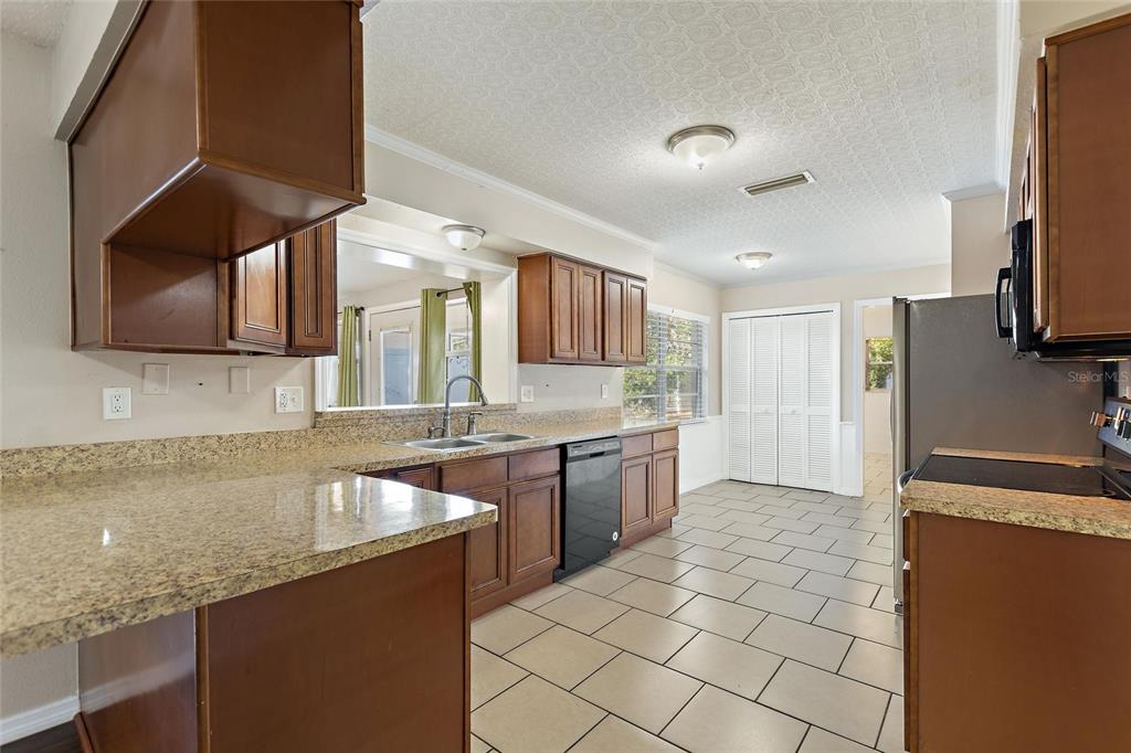 130 Audubon Road Winter Haven, FL 33884 - Photo 5 of 46 a large kitchen with granite countertop a sink a stove top oven a granite counter space and cabinets