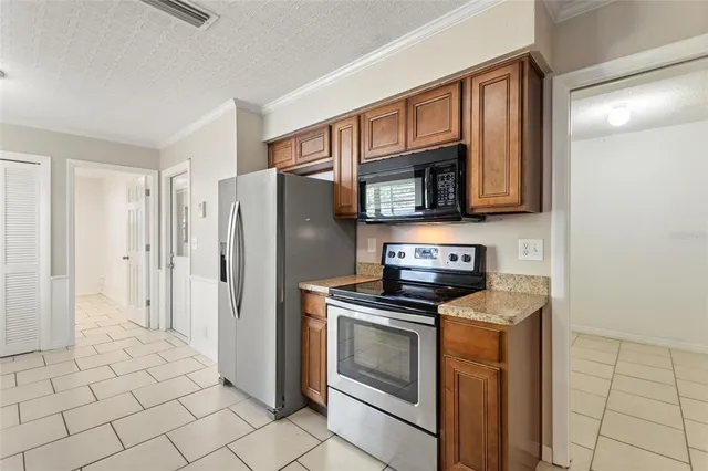 a kitchen with granite countertop a stove microwave and refrigerator