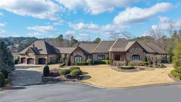 an aerial view of a house with a yard and lake view