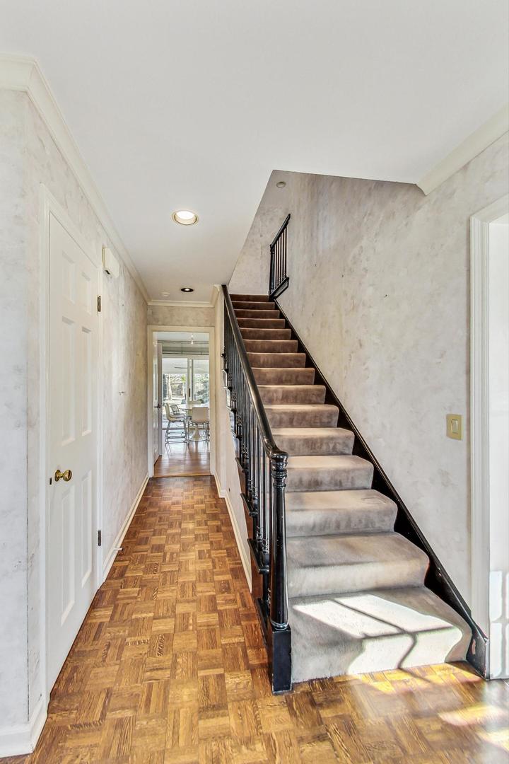 765 Walden Road Winnetka, IL 60093 - Photo 2 of 40 a view of a hallway with wooden floor and stairs