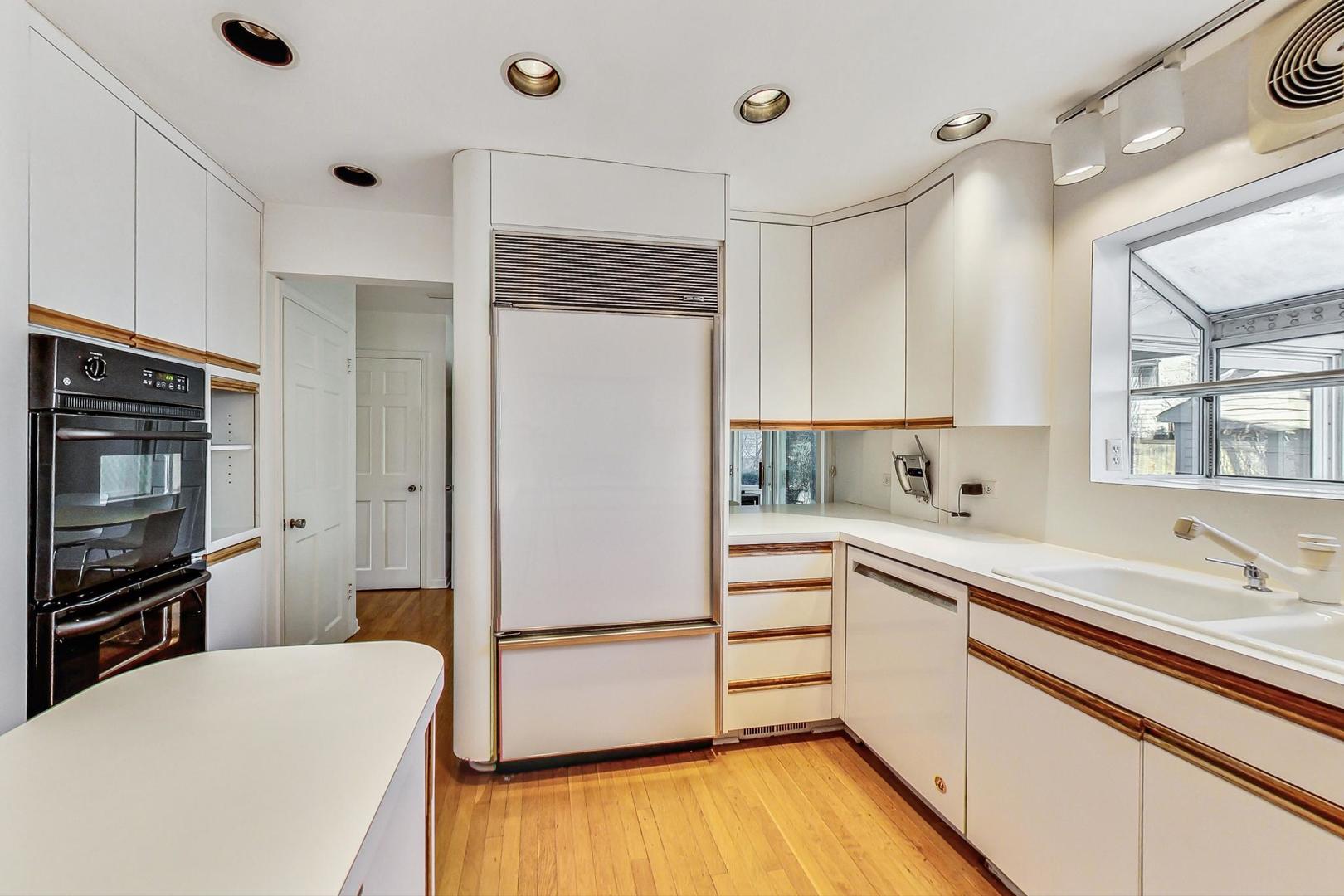 765 Walden Road Winnetka, IL 60093 - Photo 9 of 40 a kitchen with a refrigerator a sink and cabinets
