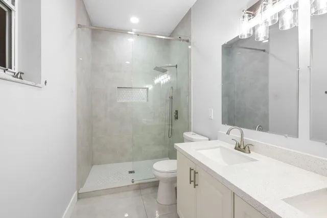 a bathroom with a sink a toilet and shower