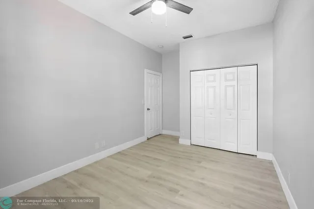 an empty room with a chandelier fan
