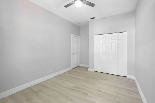 an empty room with a chandelier fan